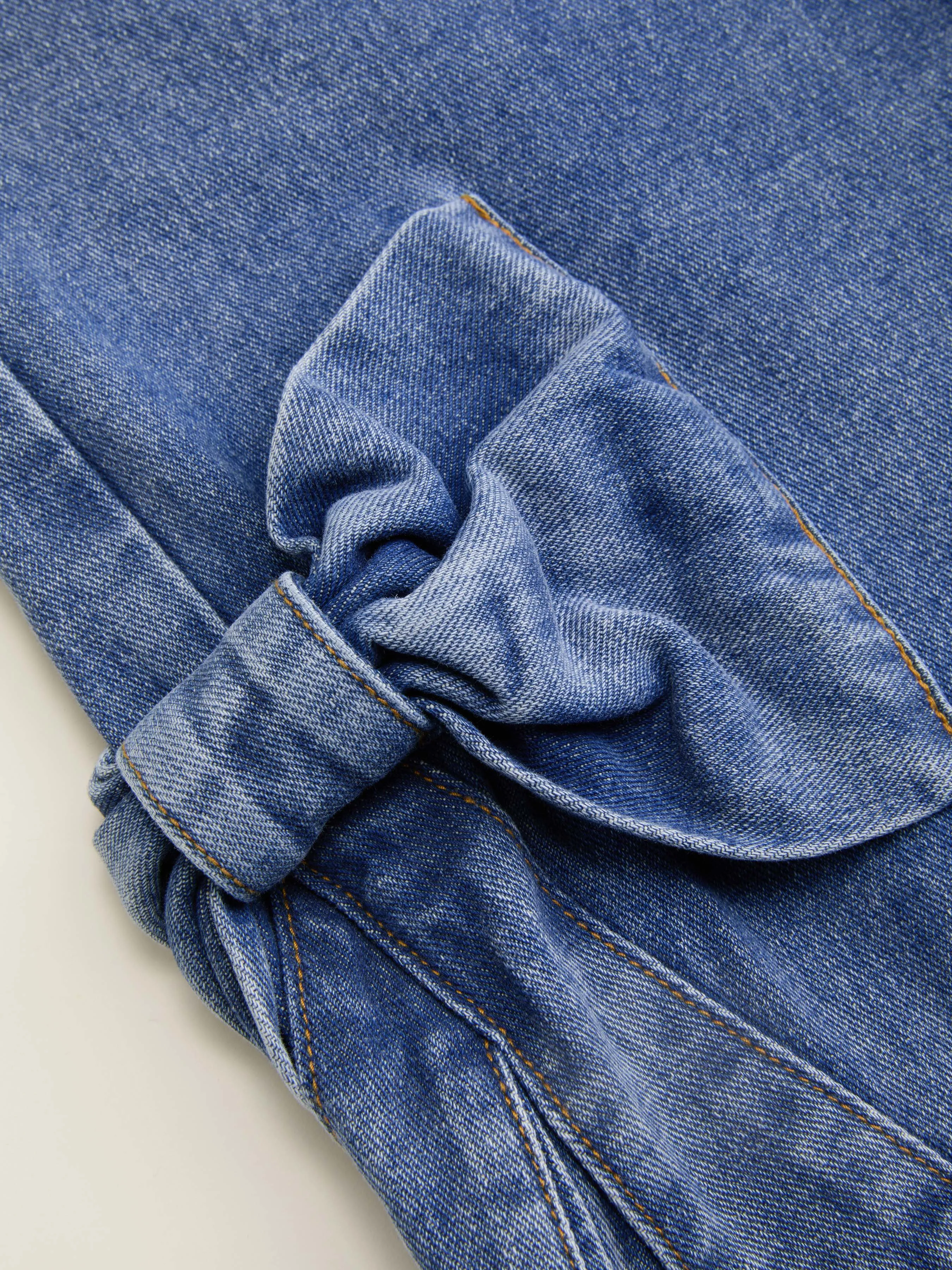 Vaqueros denim de tiro bajo con lazo y pata ancha