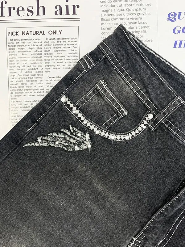 Vaqueros slim con bordado de alas de calavera